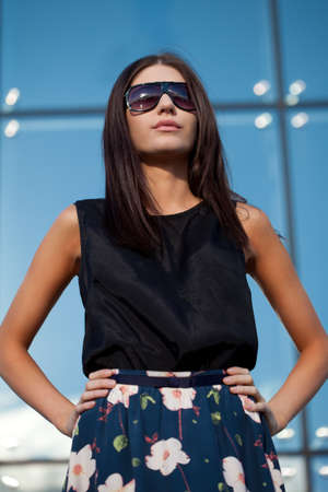 brunette woman wearing sunglasses looking far awayの写真素材