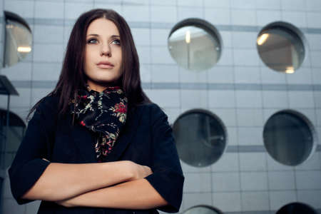 brunette woman horizontal portrait  over wall with circle windowsの写真素材