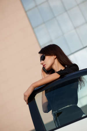 woman calling by phone near the carの写真素材
