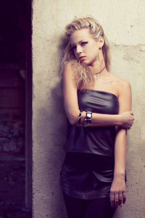 blond woman near wall wearing tunic. Fashion photoの写真素材