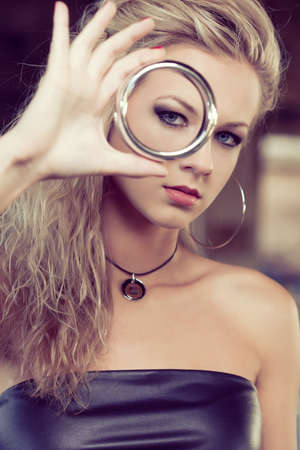 blond woman looking through bracelet. Fashion photoの写真素材