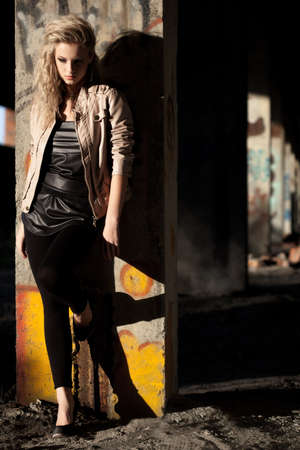 woman standing near column wearing leather jacket inside ruins. Fashion photoの写真素材