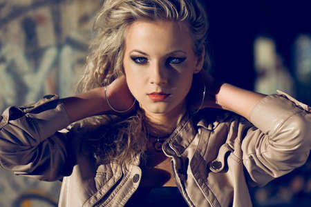 blond woman holding hands at the back wearing leather jacket isnide ruins. Fashion photoの写真素材