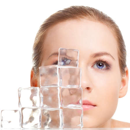 beautiful woman face near ice cubes over white backgroundの写真素材