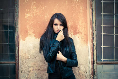 woman looking at camera and holding her collar. Specially toned photoの写真素材