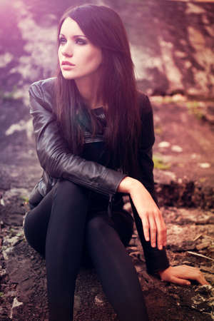 brunette woman sitting on the ground. Specially toned fashion photoの写真素材