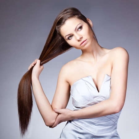woman holding her long hair. Square frame  studio portraitの写真素材