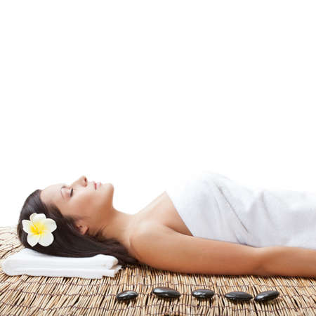 woman laying on bamboo mat in spa salonの写真素材