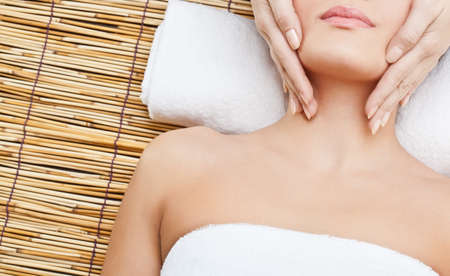 lying woman massaging her neckの写真素材