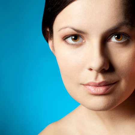 woman closeup beauty face over blue backgroundの写真素材
