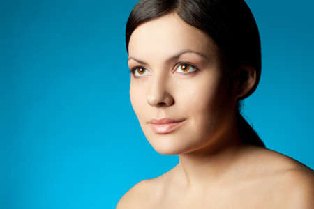woman closeup beauty face over blue background with copy spaceの写真素材