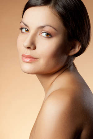 brunette woman face vertical portrait over skintone backgroundの写真素材