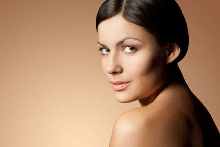 brunette woman face and shoulder over skintone backgroundの写真素材