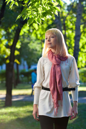 beautiful blond woman walking in the summer parkの写真素材