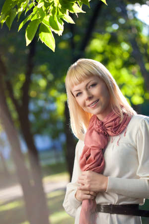 beautiful blond woman walking in the summer parkの写真素材