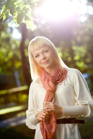 beautiful blond woman walking in the summer park, backlight flaresの写真素材
