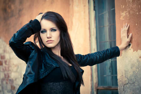 woman near cracked wall with hand on her headの写真素材