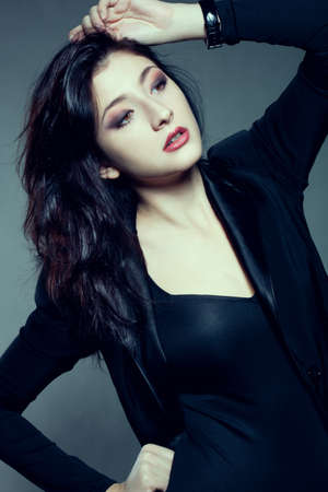 beautiful woman with dark hair holding hand on headの写真素材
