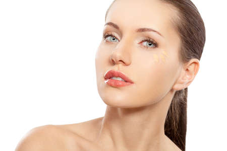 beautitful woman closeup face portrait  with foundation near eyeの写真素材