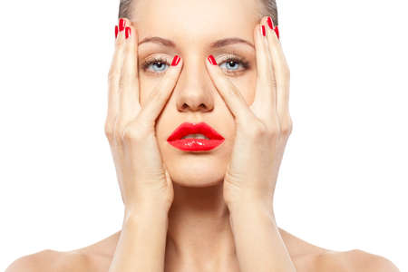 closeup woman portrait with bright red nails and lips over whiteの写真素材