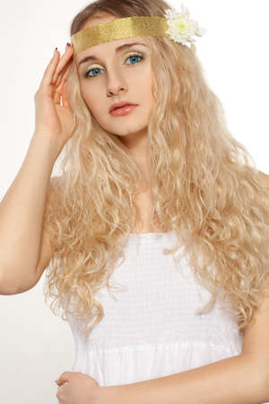 closeup woman portrait with bright blue eyes and curly hairs, gold ribbon on headの写真素材