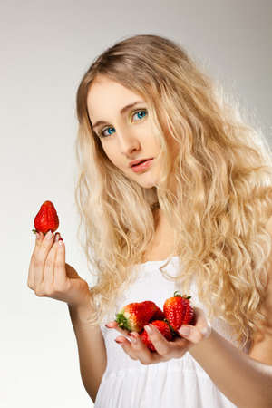 beautiful blonde woman holding strawberryの写真素材