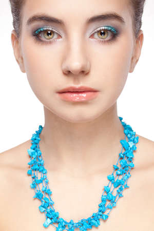 brunette woman portrait with turquoise necklace over whiteの写真素材