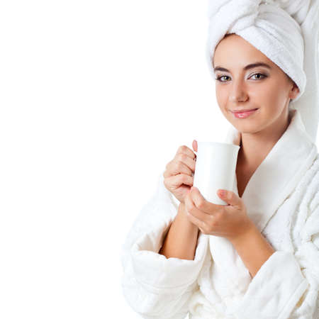 beautiful woman wearing bathrobe holding white mug, copy space for textの写真素材