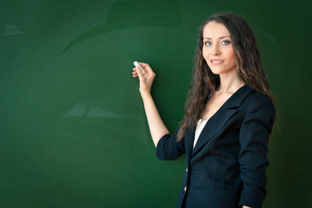 woman writing on blackboard at classroomの写真素材