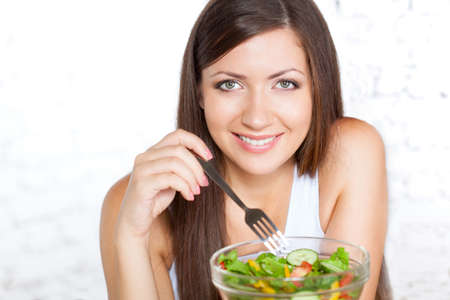happy brunette woman holding boil with saladの写真素材