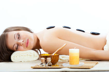 beautiful woman getting treatment with spa stones in spa salonの写真素材