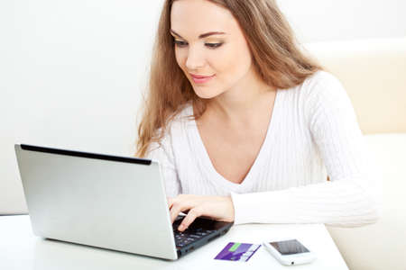 brunette woman working with laptop at her homeの写真素材