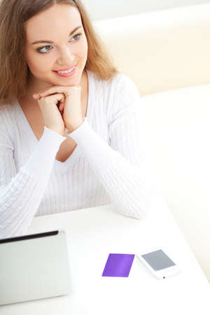 brunette woman sitting near laptop at home and dreamingの写真素材