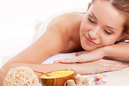 beautiful brunette woman relaxing in spa salon with closed eyesの写真素材