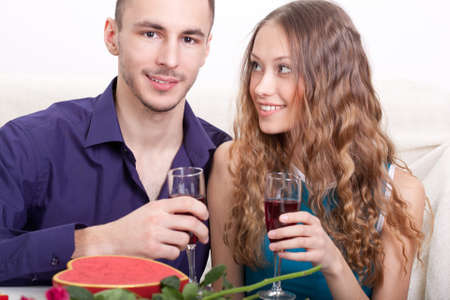 young happy  couple  drinking red wine at home interiorの写真素材