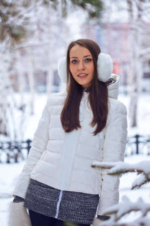 beautiful brunette woman standing in winter parkの写真素材