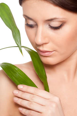 beautiful brunette woman with clear skin closeup portrait  and bamboo leavesの写真素材