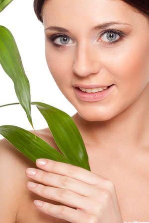 beautiful brunette woman with clear skin closeup portrait  and bamboo leavesの写真素材