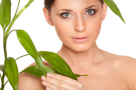 beautiful brunette woman with clear skin closeup portrait  and bamboo leavesの写真素材