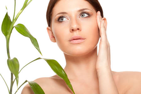 beautiful brunette woman with clear skin closeup portrait  and bamboo leavesの写真素材
