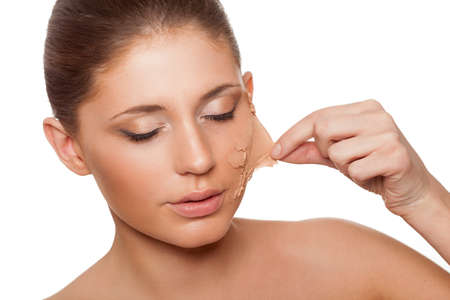 beautiful woman taking of her old dry skin from faceの写真素材