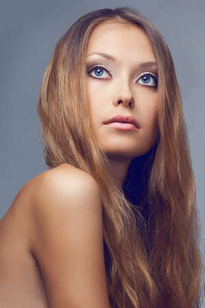closeup beautiful woman face portrait over gray backgroundの写真素材