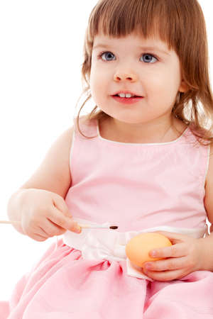 little girl painting easter eggs over white backgroundの写真素材