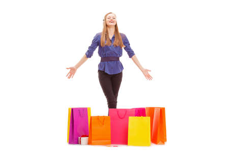 happy blonde woman with shopping bags on the floor isolated over whiteの写真素材