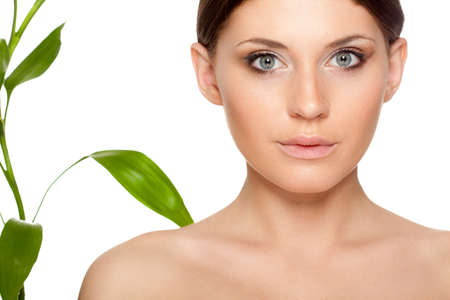 beautiful brunette woman with clear skin closeup portrait  and bamboo leavesの写真素材