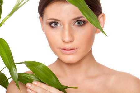 beautiful brunette woman with clear skin closeup portrait  and bamboo leavesの写真素材