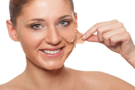 smiling brunette woman taking off her skin from face over whiteの写真素材