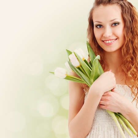 happy beautiful smiling woman holding tulipsの写真素材