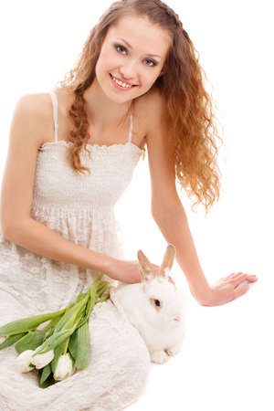 happy woman sitting on the floor with tulips and a rabbitの写真素材