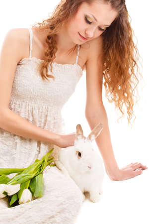 happy woman sitting on the floor with tulips and a rabbitの写真素材